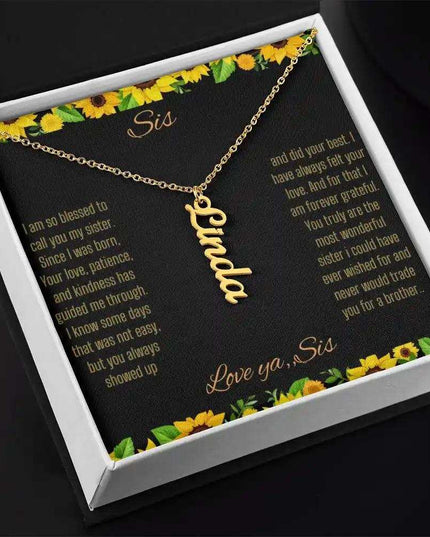 Vertical Name Necklace with a yellow gold finish on a To Sis From Sis greeting card inside a two-tone box close up angled slightly to right