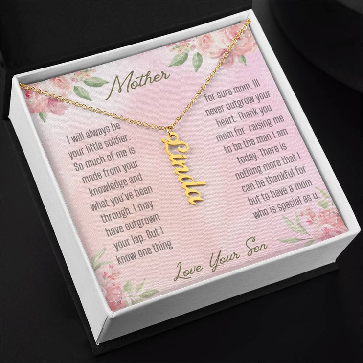A yellow gold finish vertical name necklace in two-tone box angled to left.