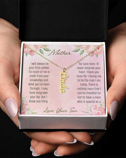 A yellow gold finish vertical name necklace in models hands.