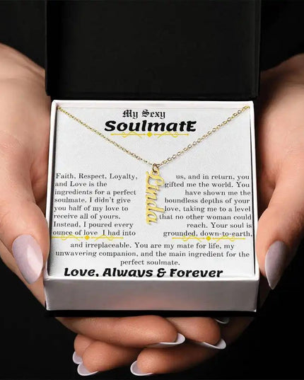a yellow gold vertical name necklace in a models hands