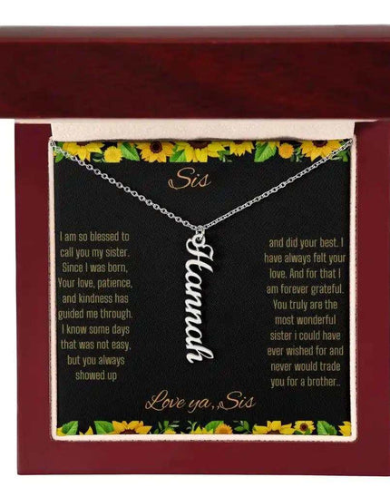 Vertical Name Necklace with a polished stainless-steel finish on a To Sis From Sis greeting card inside a mahogany box