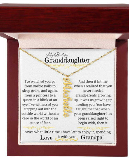 a yellow gold vertical name necklace up close in a mahogany box.