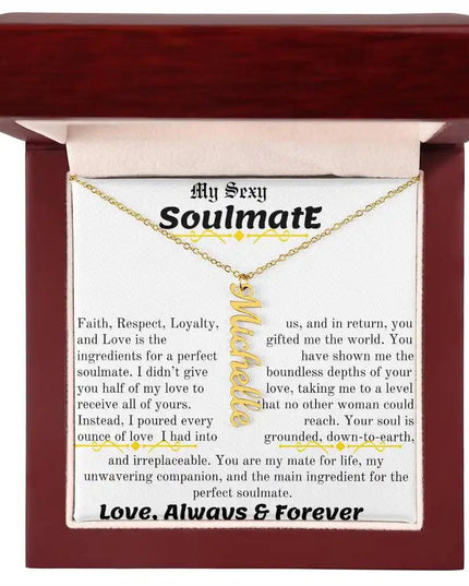 a yellow gold vertical name necklace in a mahogany box
