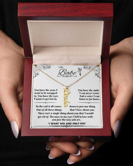 yellow gold vertical name necklace in a luxury box in model's hands