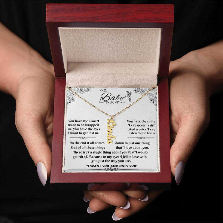 yellow gold vertical name necklace in a luxury box in model's hands