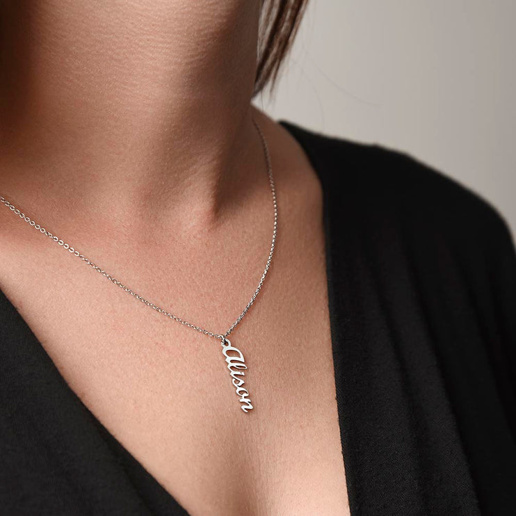 a polished stainless-steel vertical name necklace on a models neck