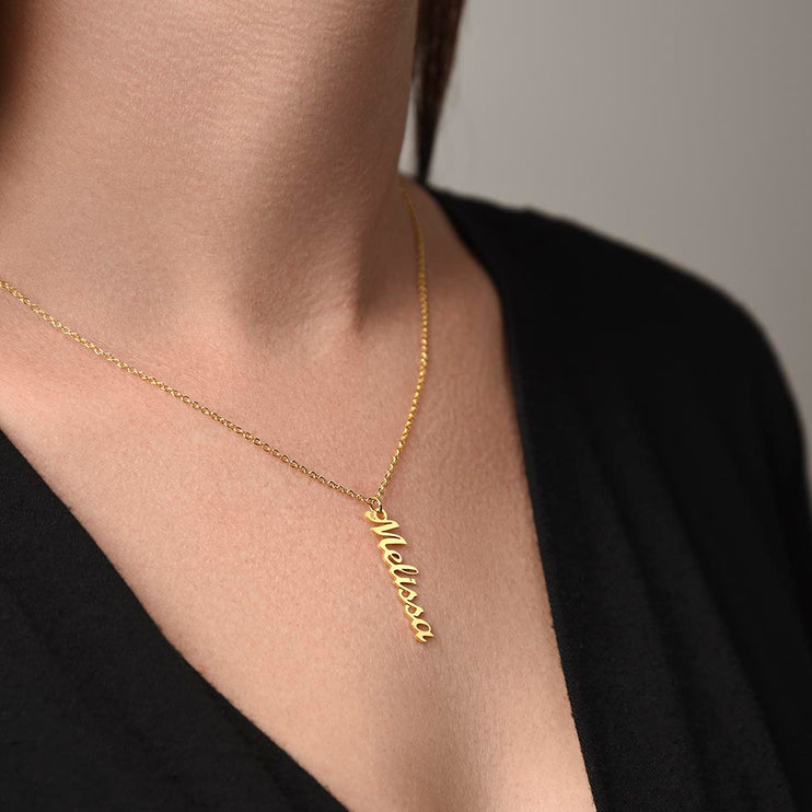 a yellow gold vertical name necklace ona models neck