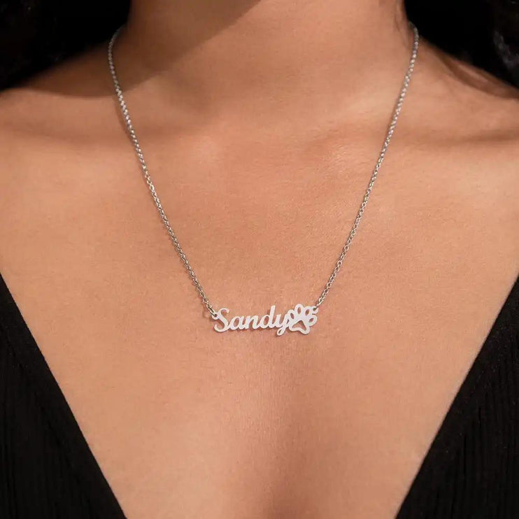 polished steel paw print pet name necklace on model's neck