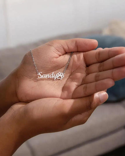 polished stainless paw print pet name necklace in model's hand