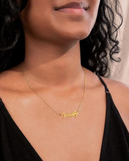 gold paw print pet name necklace on model's neck