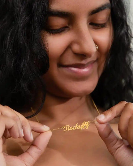 Pet Name Paw Print Necklace with a yellow gold finish variant on a female models neck