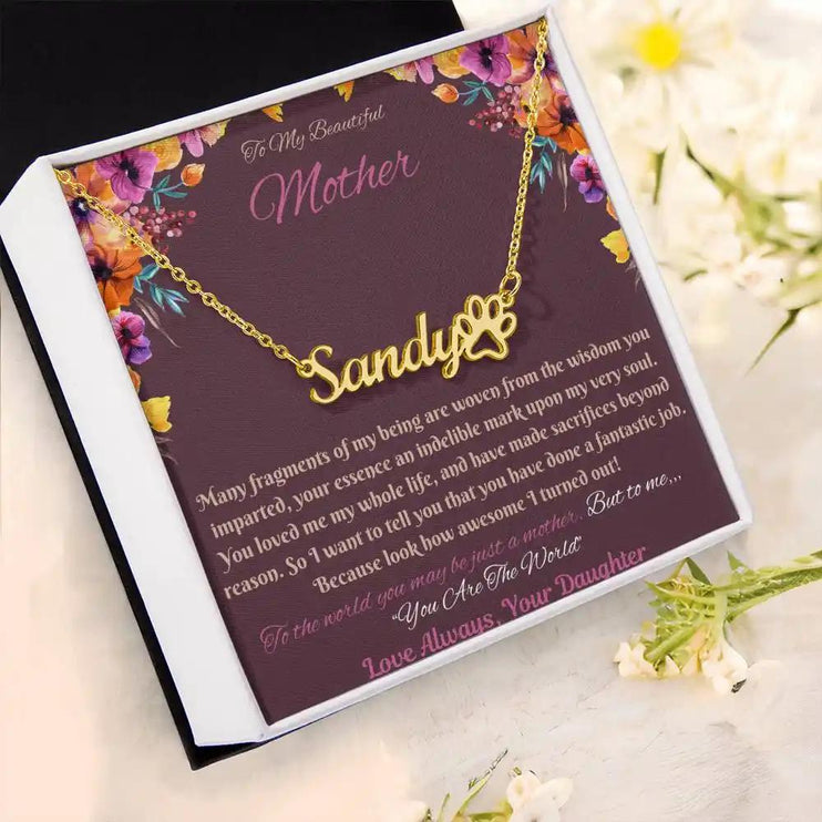 gold paw print pet name necklace in soft box angled left