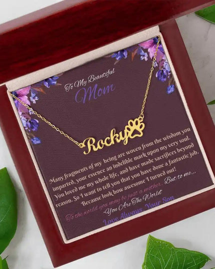 gold paw print pet name necklace in mahogany box angled left