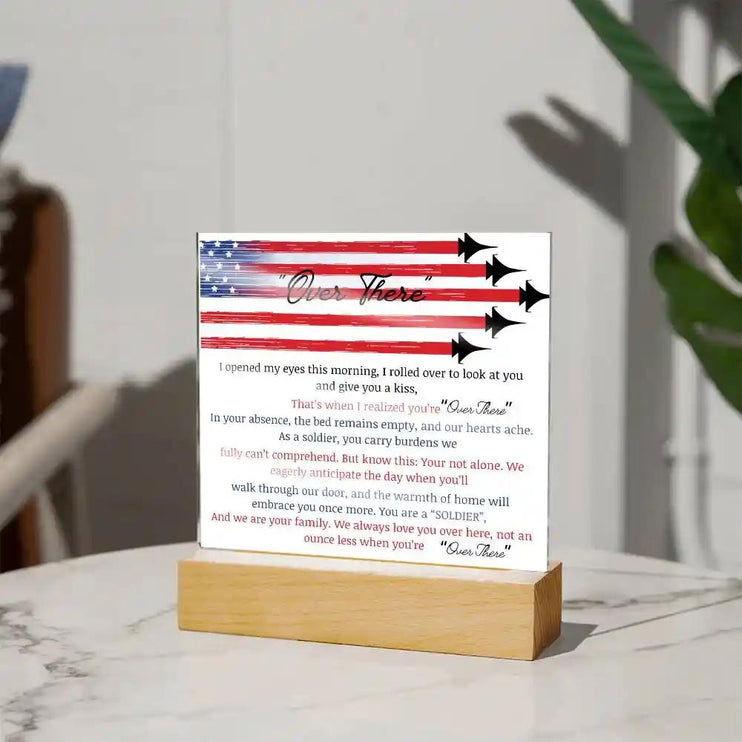 A acrylic square plaque with heartfelt message "over there" on a table