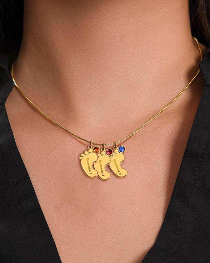 Engraved Baby Feet Charm And Birthstone Necklace with 3 yellow gold finished charms on a model