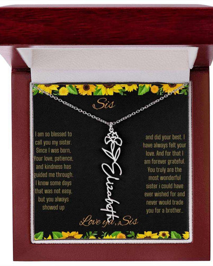 Birth Flower Name Necklace with a polished stainless-steel variant of a flower on a To Sis from Sis message card in a mahogany box up close