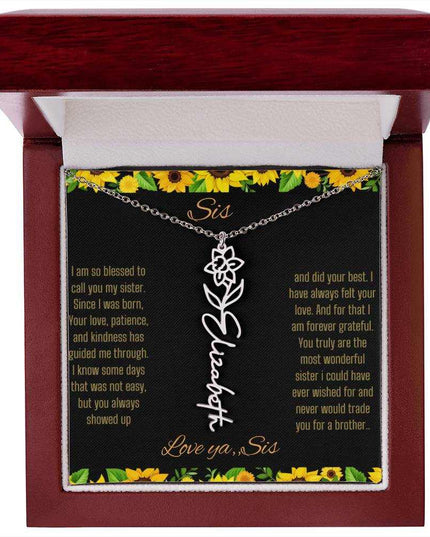 Birth Flower Name Necklace with a polished stainless-steel variant of a flower on a To Sis from Sis message card in a mahogany box up close