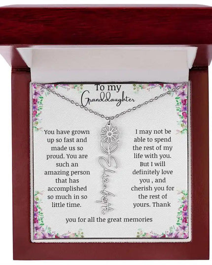 a polished stainless-steel April birth flower name necklace in a mahogany box.
