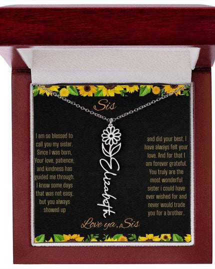 Birth Flower Name Necklace with a polished stainless-steel variant of a flower on a To Sis from Sis message card in a mahogany box up close