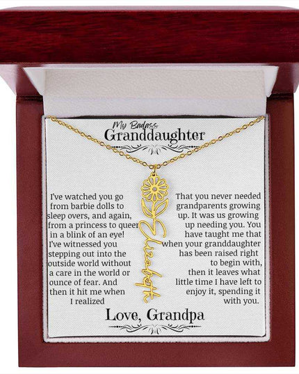 a yellow gold flower name necklace j in a mahogany box.