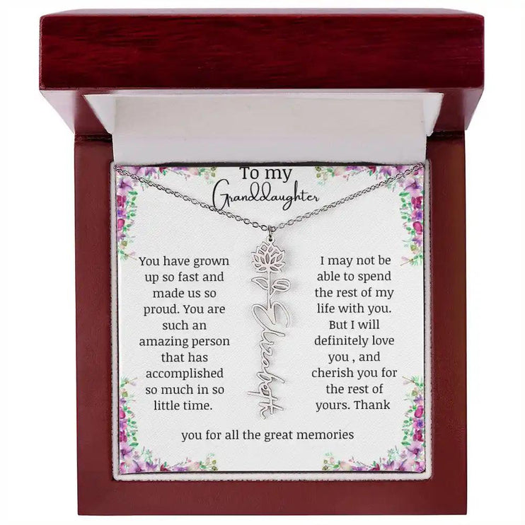 a polished stainless-steel July birth flower name necklace in a mahogany box.