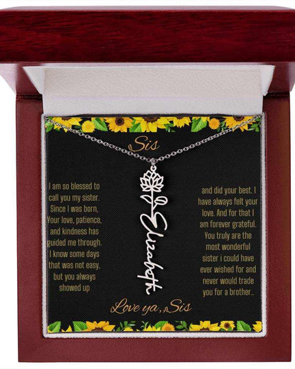 Birth Flower Name Necklace with a polished stainless-steel variant of a flower on a To Sis from Sis message card in a mahogany box up close