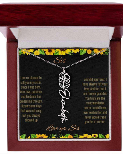 Birth Flower Name Necklace with a polished stainless-steel variant of a flower on a To Sis from Sis message card in a mahogany box up close
