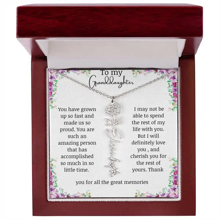 a polished stainless-steel October birth flower name necklace in a mahogany box.