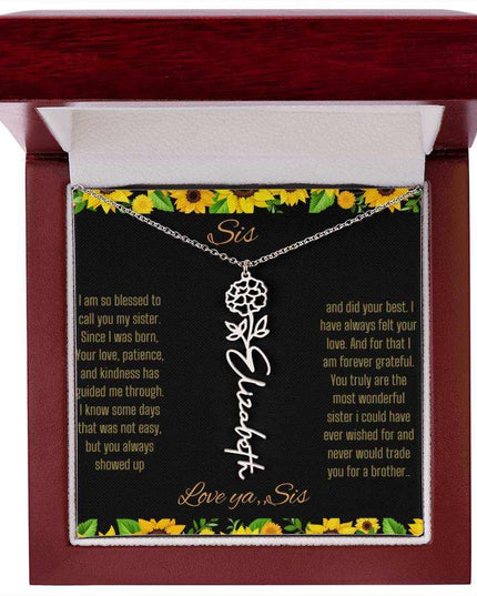 Birth Flower Name Necklace with a polished stainless-steel variant of a flower on a To Sis from Sis message card in a mahogany box up close