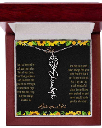 Birth Flower Name Necklace with a polished stainless-steel variant of a flower on a To Sis from Sis message card in a mahogany box up close