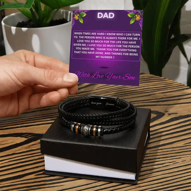 A men's love you forever bracelet in a two-tone box with a to dad greeting card on a wood grain table