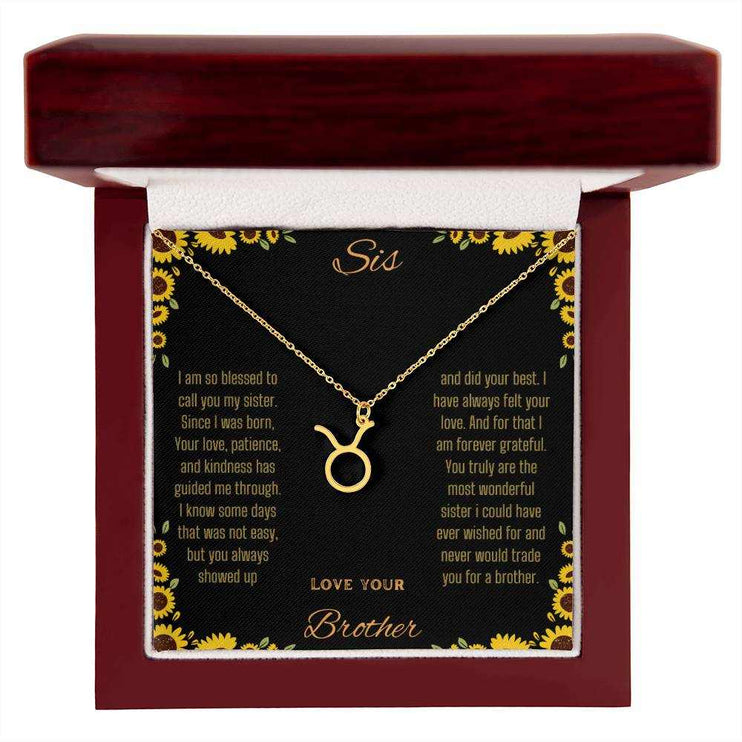 Zodiac Symbol Necklace with a yellow gold finish Taurus charm on a to sis from brother greeting card inside a mahogany box
