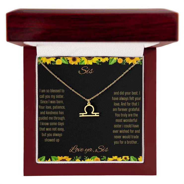 Zodiac Symbol Necklace with a yellow gold Libra charm on a to sis from sis greeting card inside a mahogany box