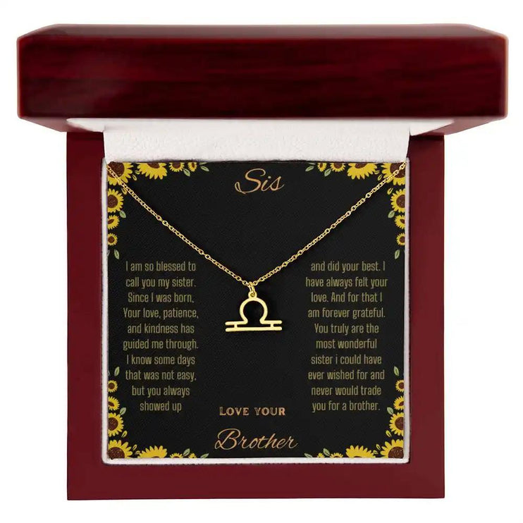 Zodiac Symbol Necklace with a yellow gold finish Libra charm on a to sis from brother greeting card inside a mahogany box