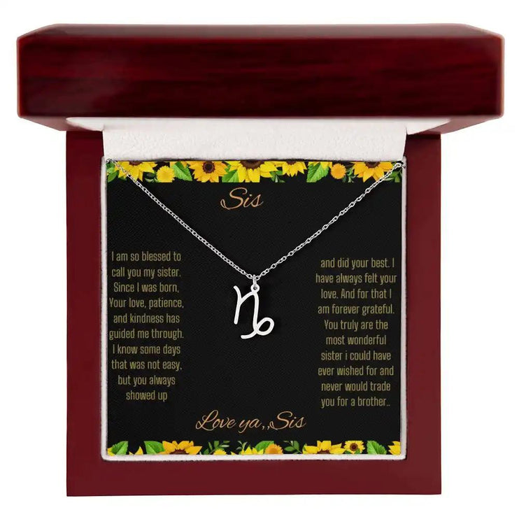 Zodiac Symbol Necklace with a polished stainless-steel Capricorn charm on a to sis from sis greeting card inside a mahogany box