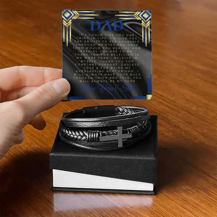 A men's cross leather bracelet in a two-tone box with a to dad greeting card on a table
