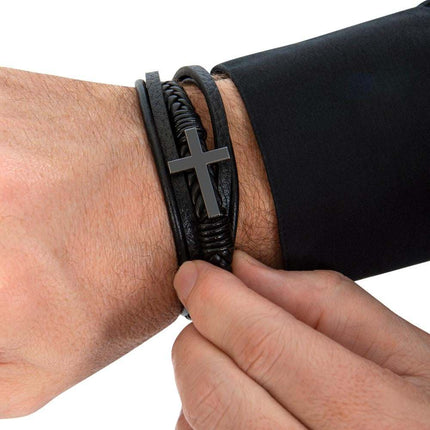 cross leather bracelet on a model's wrist with other hand touching bracelet