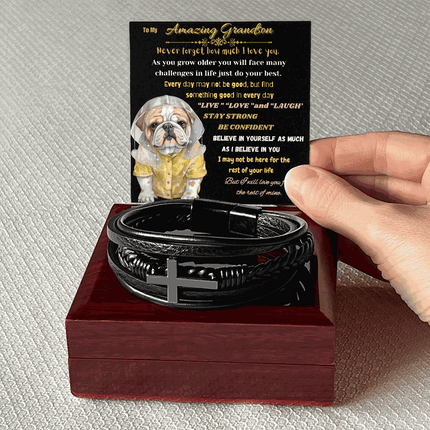 cross bracelet on top of a closed mahogany box with card