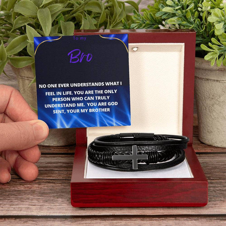 men's cross leather bracelet with to my brother message card and mahogany box with hand holding message card and plants in backdrop