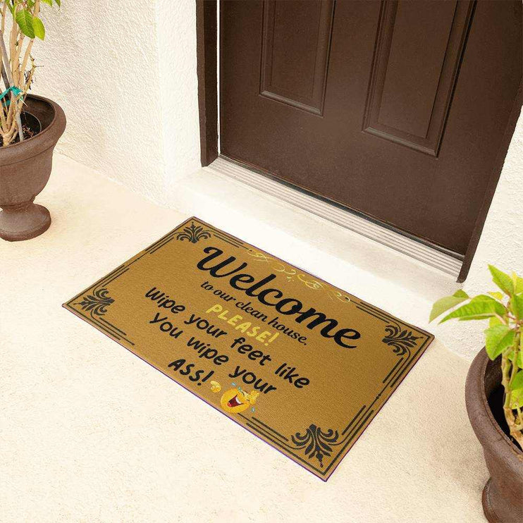 welcome mat by brown door with plants