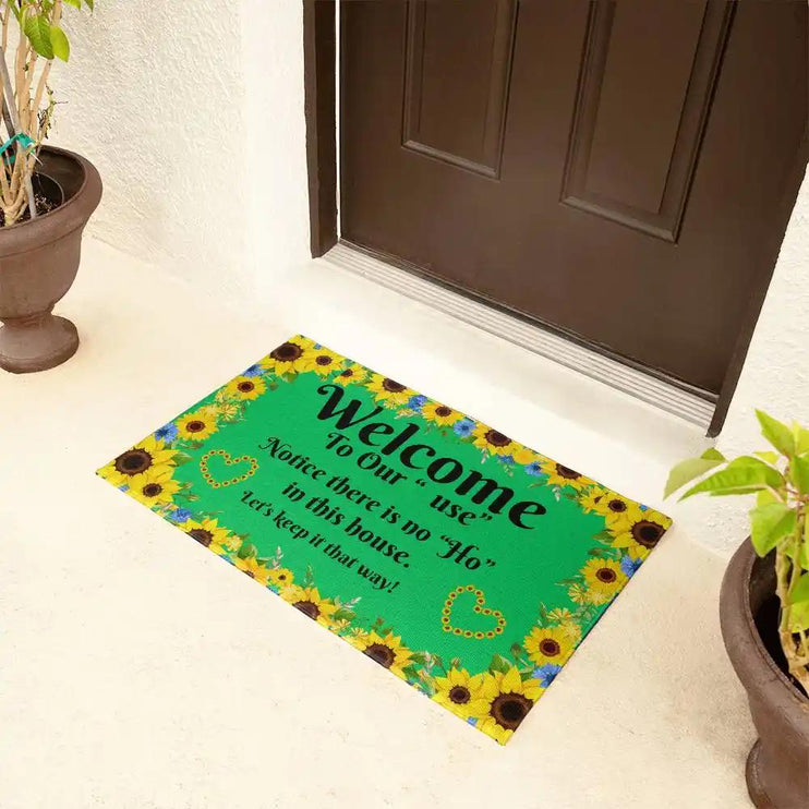 welcome mat in front of brown door with plants