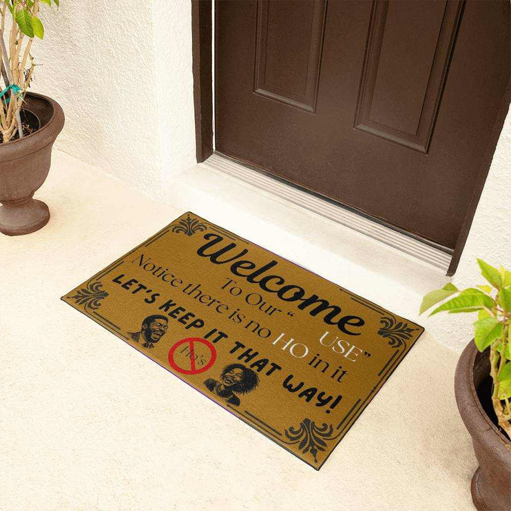 welcome mat in front of brown door with plants