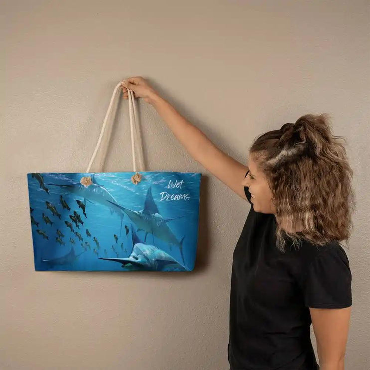a weekend tote bag with rope straps with model holding it on the wall