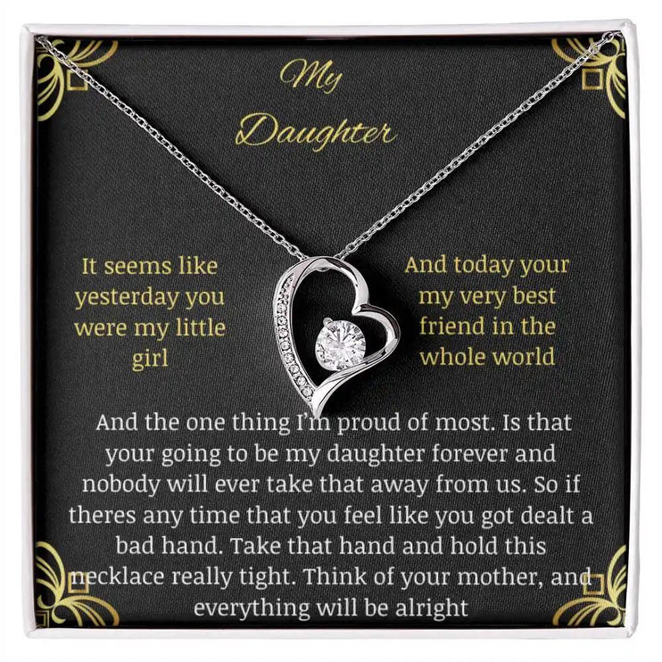 Forever Love Necklace with a white gold pendant in a two-toned box with a greeting card to daughter from mother close up looking down