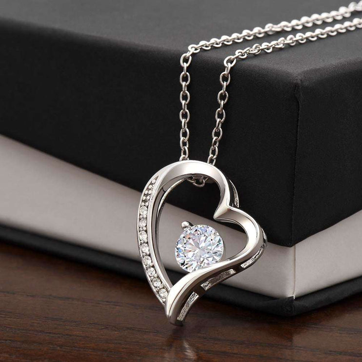 white gold forever love necklace on top of soft box