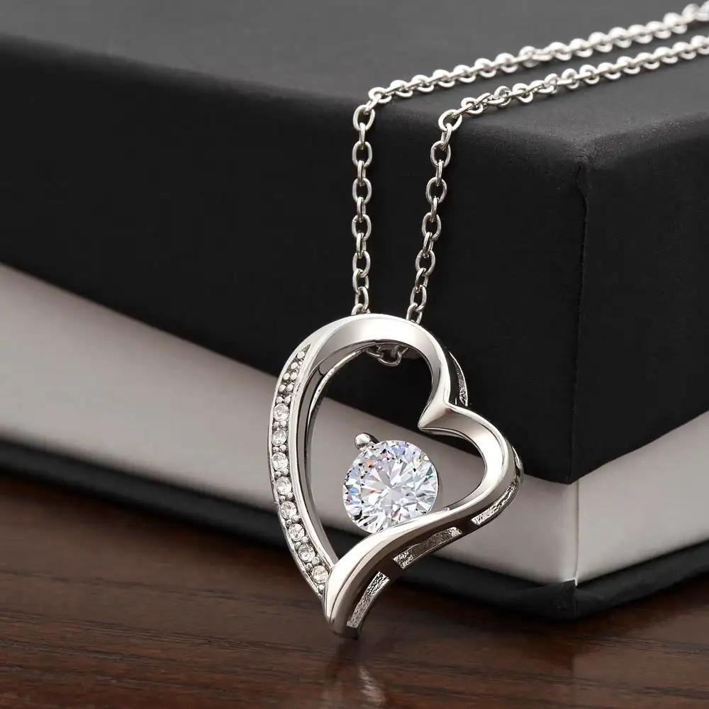 white gold forever love necklace on top of a two-tone box