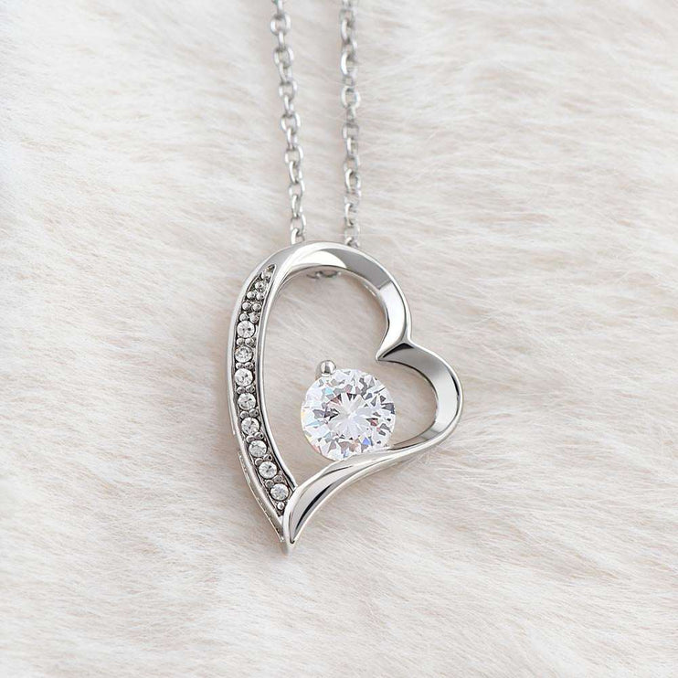 white gold forever love necklace on a white plush cloth