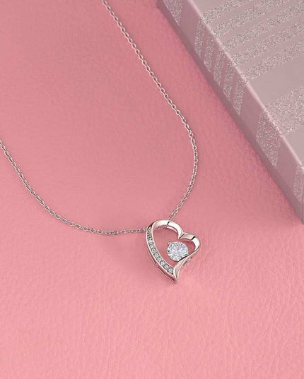 white gold forever love necklace on a pink display table