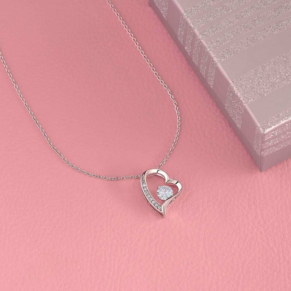 white gold forever love necklace on a pink cloth