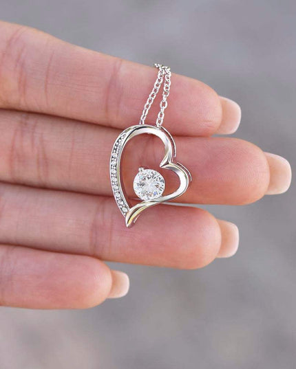 white gold forever love necklace in a model's hand